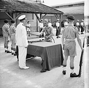 イギリス海軍の中尉に軍刀を引き渡す日本海軍の将校（サイゴンの降伏式）