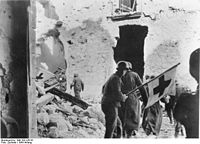 Deutsche Sanitäter bei der Bergung von Verwundeten unter dem Schutzzeichen des Roten Kreuzes bei der Schlacht um Monte Cassino (Januar 1944).