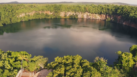 Photographie montrant les falaises bordant le lac et la végétation autour, ainsi qu'un belvédère au premier plan.