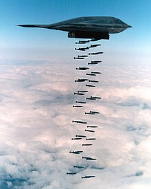 a B-2 Spirit bomber dropping several dozen bombs