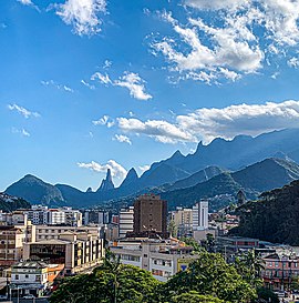 Vista parcial do Centro de Teresópolis, com o pico Dedo de Deus e as demais montanhas que formam a Serra dos Órgãos ao fundo.