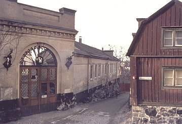 Duvogränd på Södermalm sedd från Ludvigsbergsgatan mot norr. Till vänster på bilden syns den eleganta entrén till Villa Ludvigsberg som uppfördes 1859–1860 efter ritningar av arkitekt Johan Fredrik Åbom för Jacques Lamm, ägaren av Ludvigsbergs Mekaniska Verkstad. Till höger ligger fastigheten Ludvigsberg 14 med trähusbebyggelse från 1750-talet.