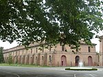 A brick building behind a tree