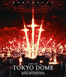 A series of orange-yellow pyrotechnics stand out in a group of three, shaped like crosses, above a group of buildings with a dark, red sky; "BABYMETAL" appears at the top, and "LIVE AT", "TOKYO DOME", "BABYMETAL WORLD TOUR 2016", "LEGEND -METAL RESISTANCE-", and "RED NIGHT & BLACK NIGHT" appear at the bottom, all in white, all caps text.