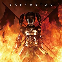 A girl with pigtails wearing a suit of armor also obscuring her face. Flames surround her and the background, and two flags stand behind her crossed in an "X" shape. The word "BABYMETAL" appears above in white font.