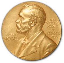 Medali emas dengan gambar timbul pria berjenggot menghadap kiri. Di sebelah kiri pria tersebut tertulis "ALFR•" dan "NOBEL", di sebelah kanan, tulisan yang lebih kecil "NAT•" dan "MDCCCXXXIII" di bagian atas, diikuti "OB•" dan "MDCCCXCVI" di bagian bawah.
