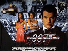 A man wearing an evening dress holds a gun. On his sides are a white woman in a white dress and an Asian woman in a red, sparkling dress holding a gun. On the background are monitors with scenes of the film, with two at the top showing a man wearing glasses holding a baton. On the bottom of the screen are two images of the 007 logo under the title "Tomorrow Never Dies" and the film credits.