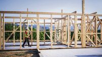 Builder Working On Wooden House In Nature.