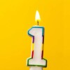 A yellowish-gold background with a lit number 1 candle.