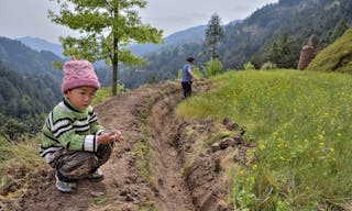 Langde Village, Guizhou, China - April 15, 2010: Rural China, mountainous terrain, unidentified boy about 4 years old is sitting