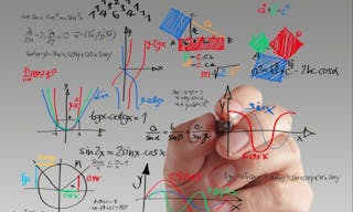 male teacher writing various high school maths and science formula on whiteboard