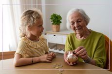 Grandparent and granddaughter counting money