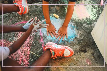 Sensory play with mother helping child to pain with their hands