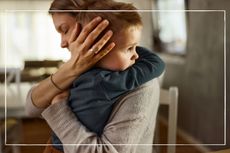 Mother hugging a worried little boy at home