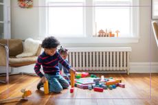 Brother and sister playing on floor at home 