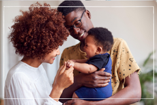 A couple holding and smiling at their baby