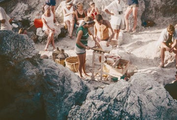 a group of people standing around a table with baskets on it