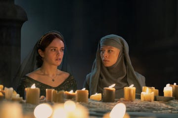 a couple of women sitting at a table with candles