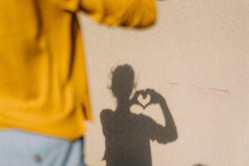 shadow of a woman shaping a heart with her hands