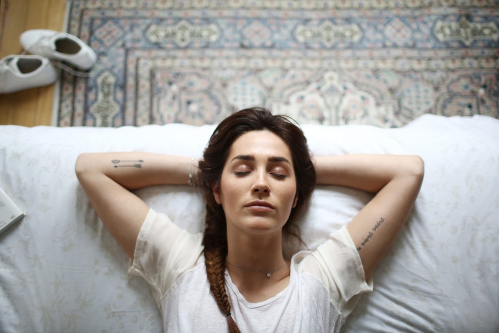 a young woman laying on her bed