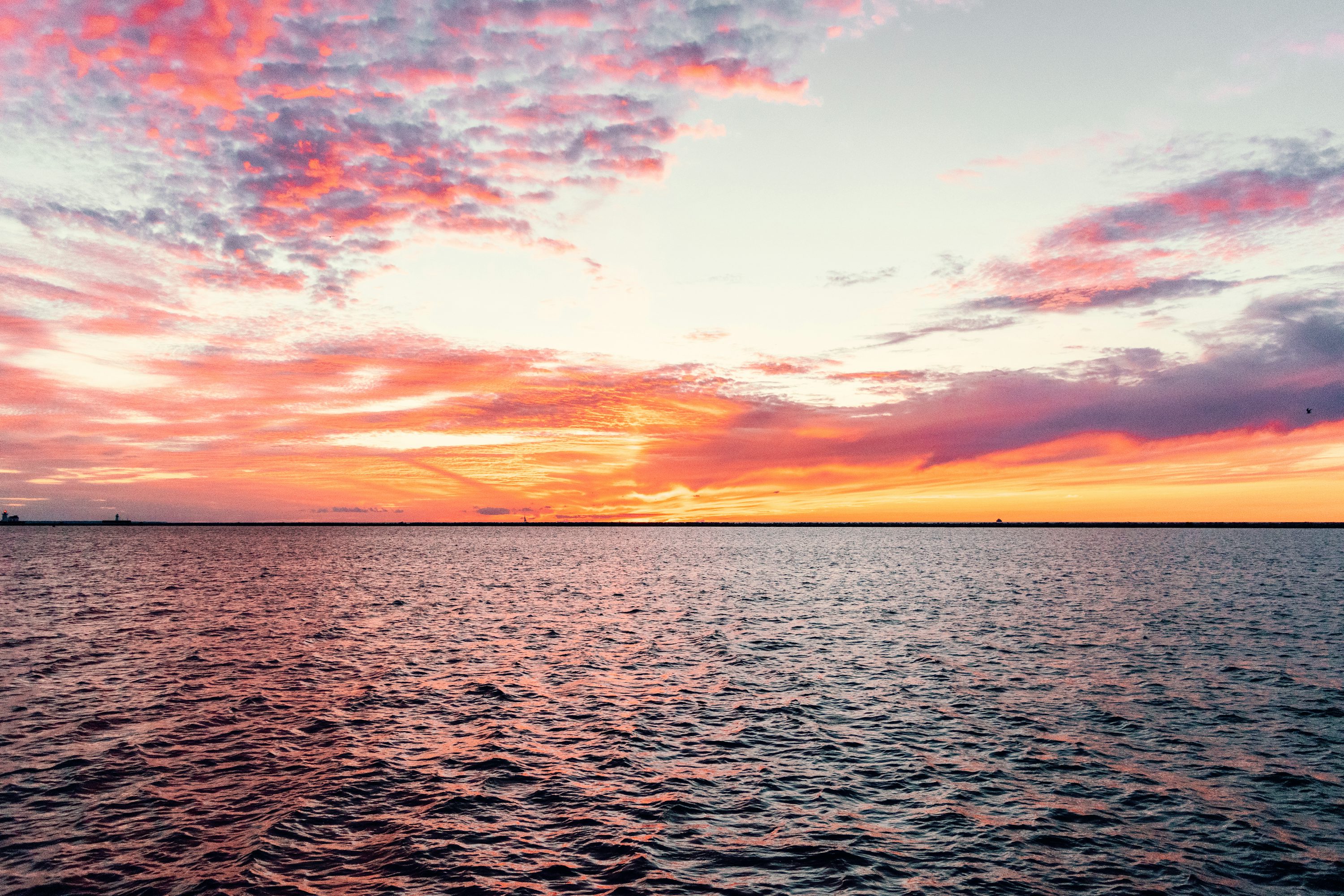 body of water under cloudy sky during sunset