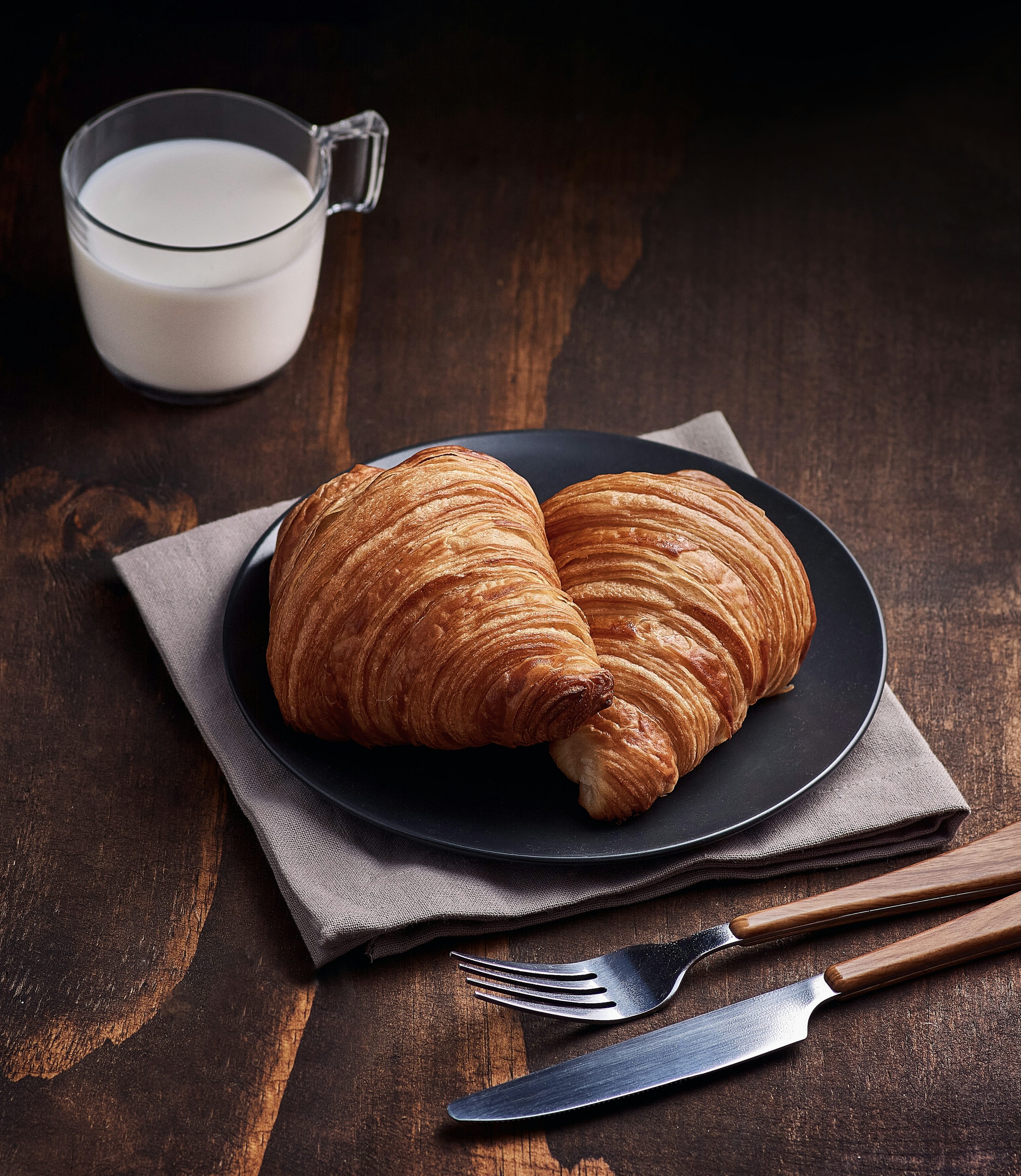 bread on brown wooden tray beside white ceramic mug