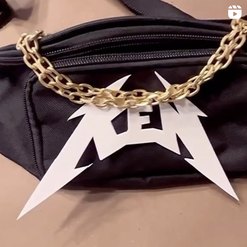 Closeup of black fanny pack with a gold chain and name "Ken"