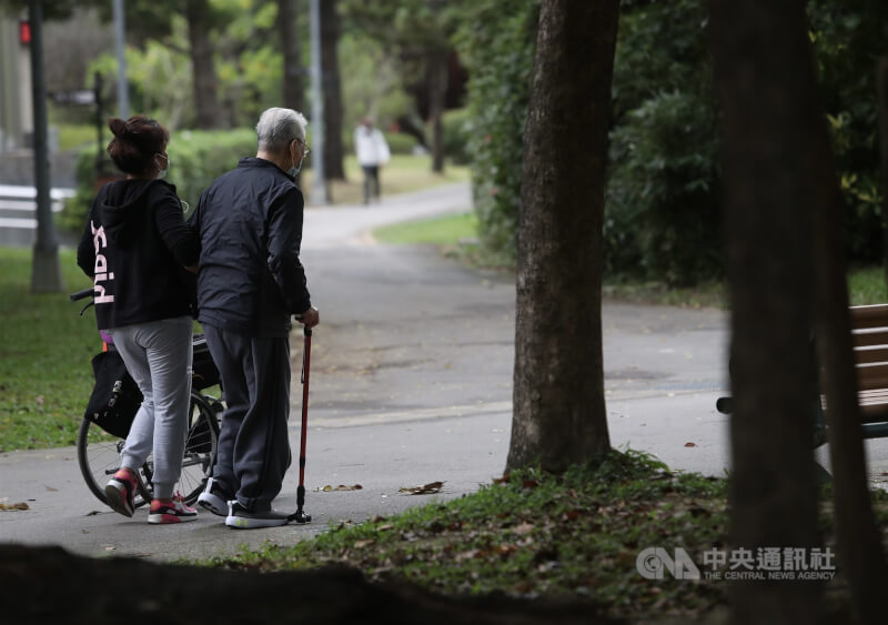 圖為外籍幫傭與雇主在公園內散步。（中央社檔案照片）