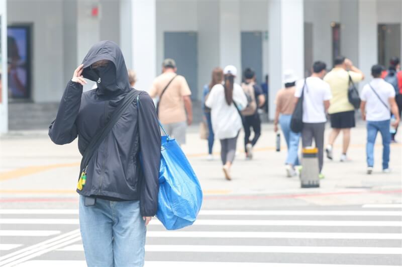 圖為台北西門町商圈有民眾全身包緊緊防曬。（中央社檔案照片）