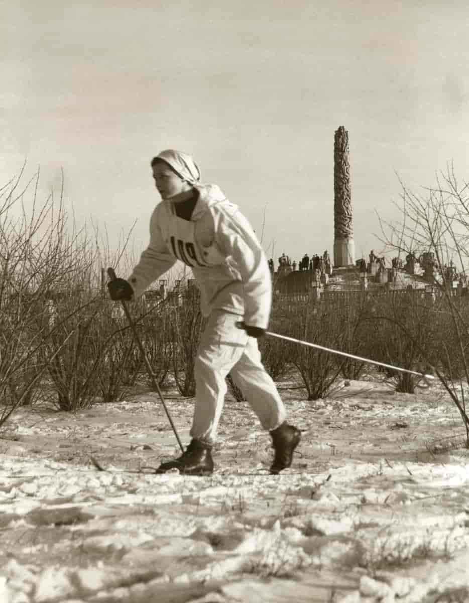 Ingrid Wigernæs kledd i en lys og romslig skidress går diagonalgang i Frognerparken. 