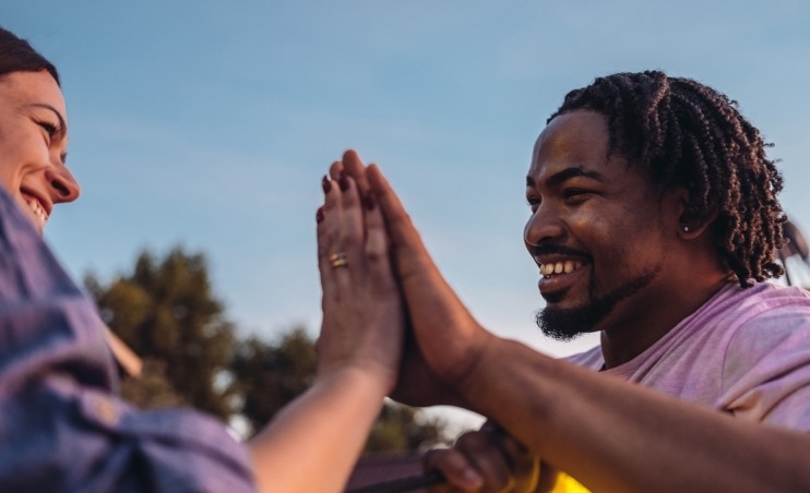 Two adult giving each other a high five.