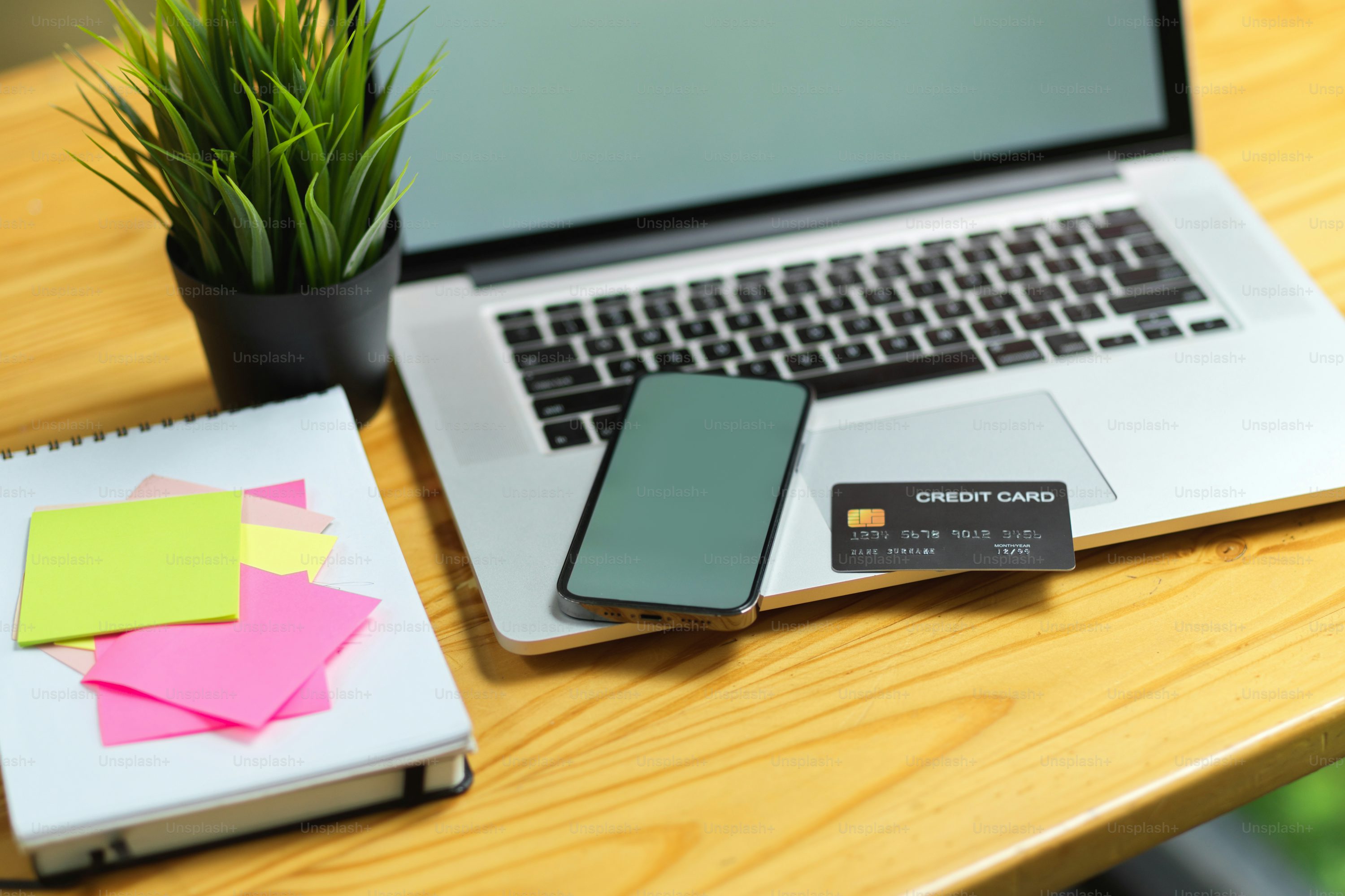 Close up of mobile phone and laptop  empty screen mock up with credit card, sticky notes on desk