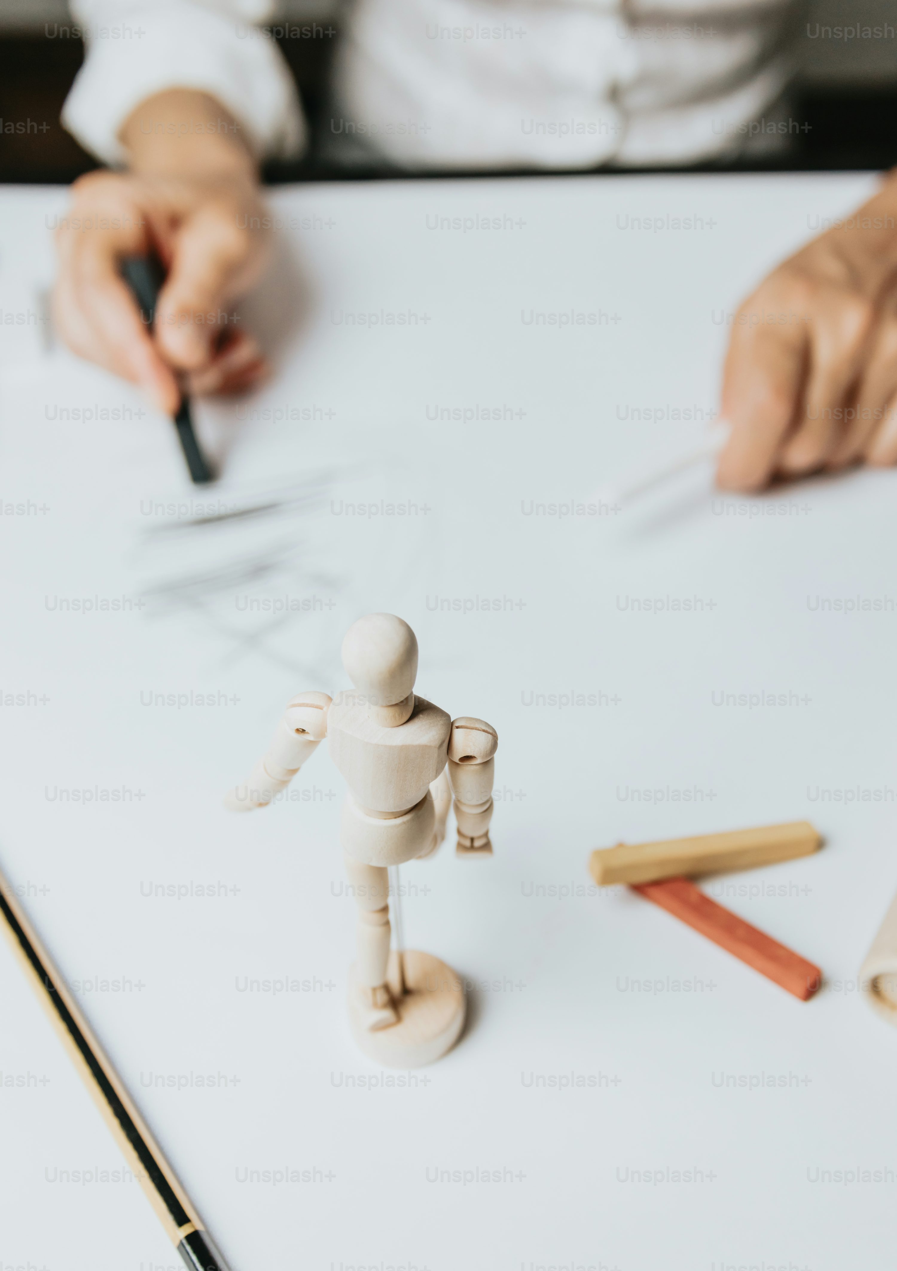 a small wooden man standing on top of a white table