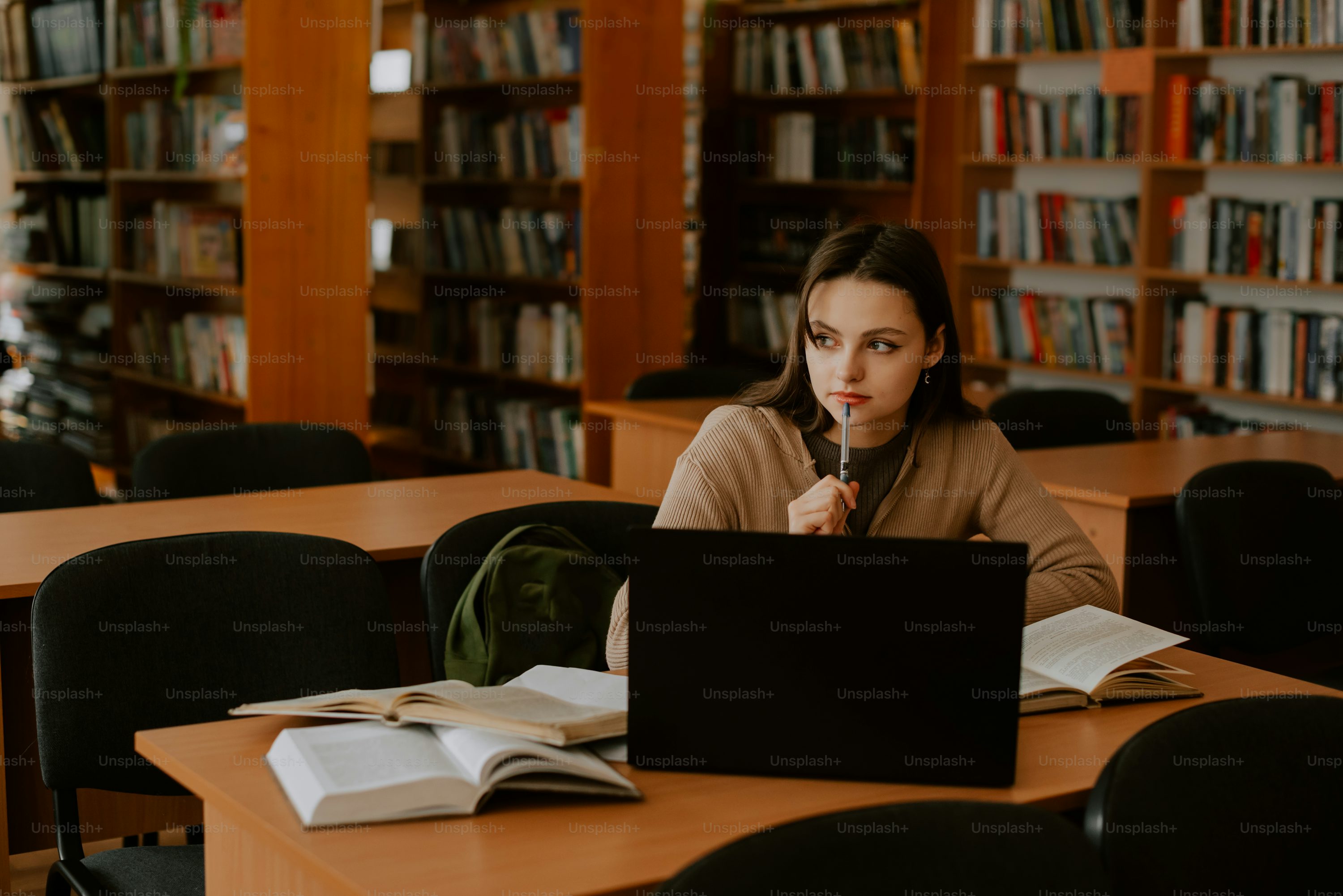 a woman sitting at a table in front of a laptop computer