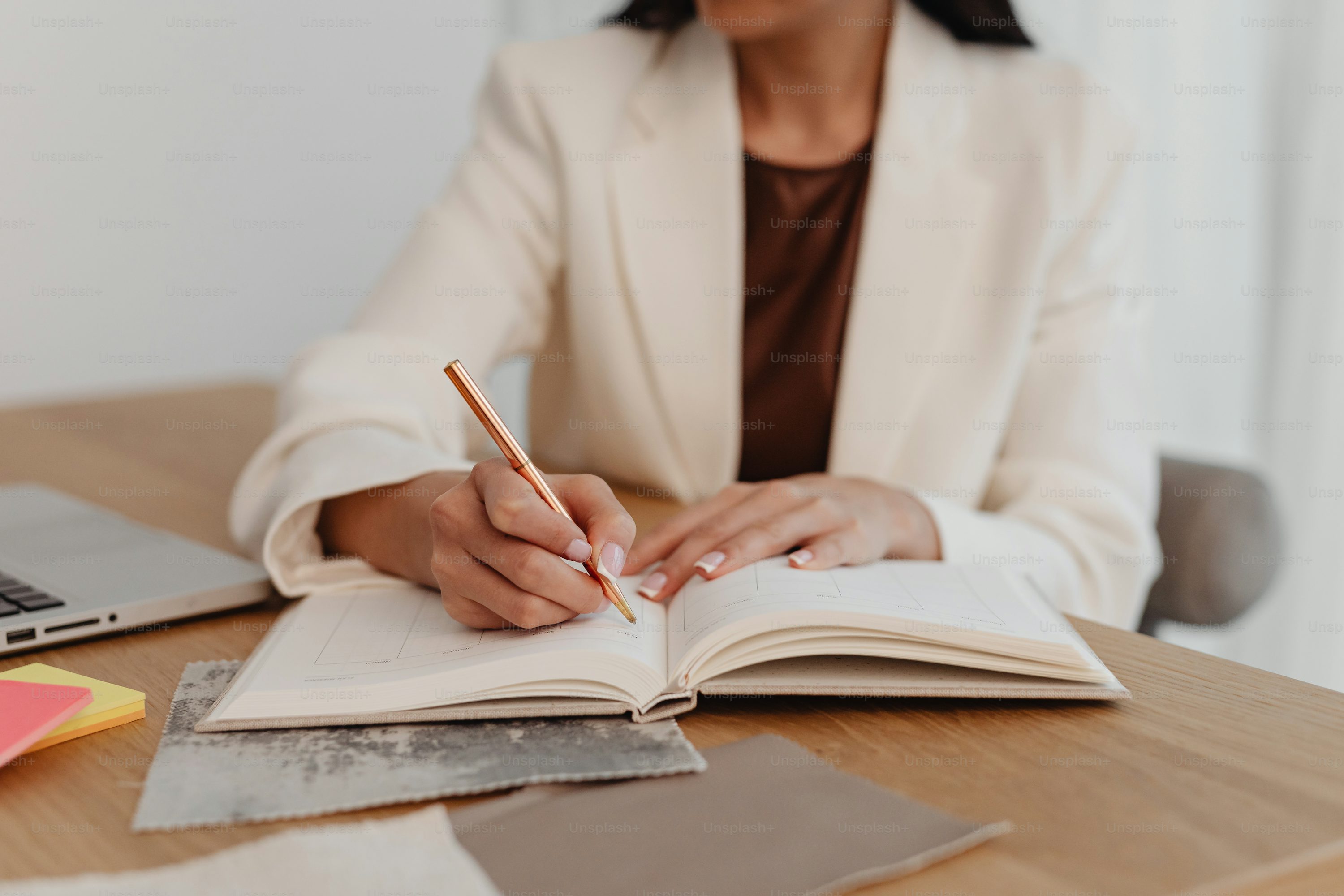 a woman sitting at a desk writing on a book