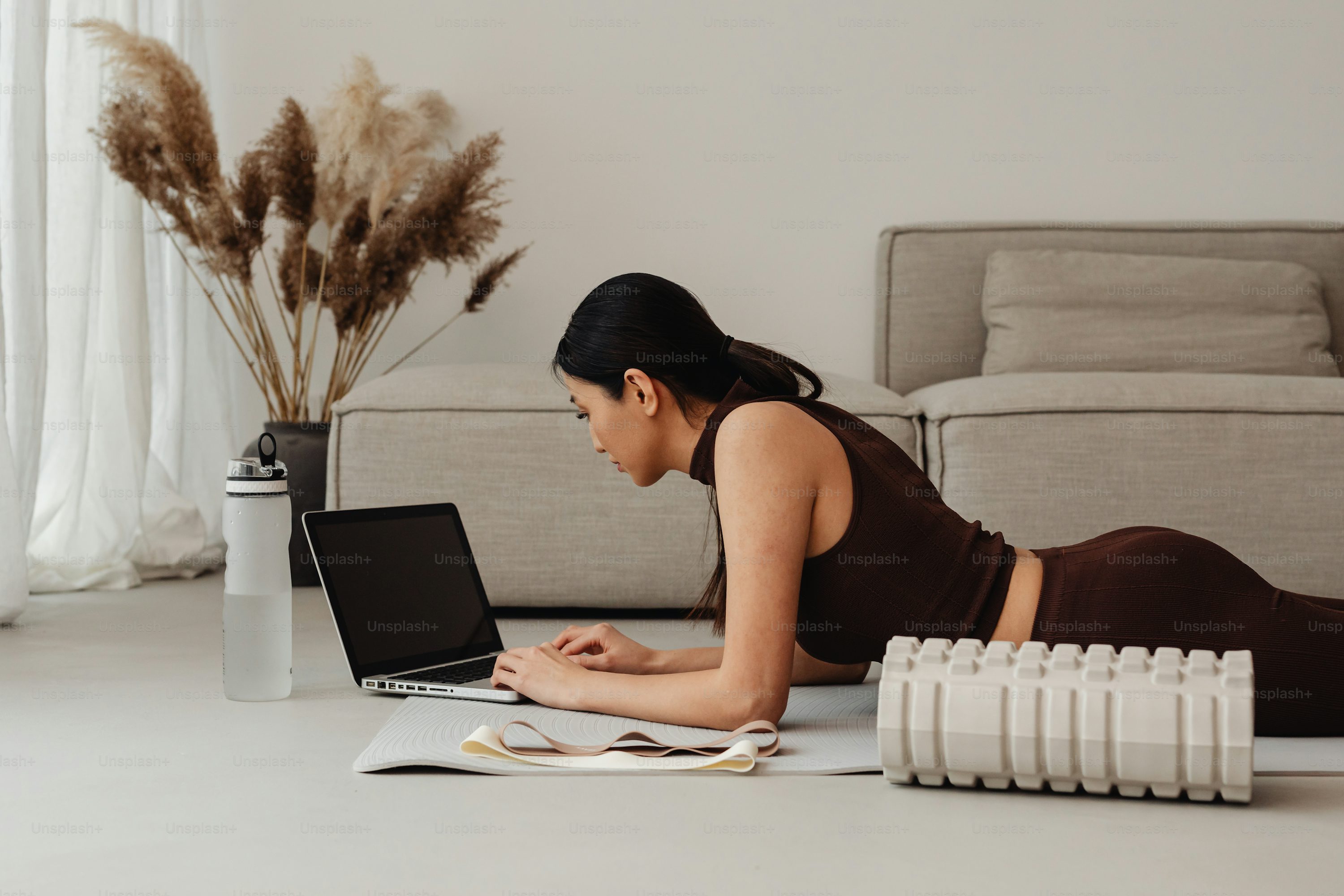 a woman laying on the floor using a laptop