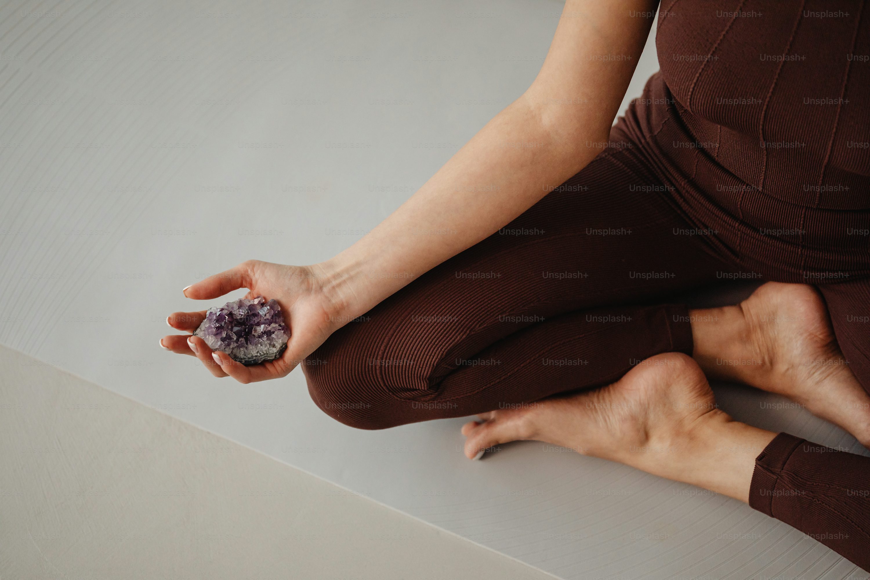 a woman is sitting on the floor with a rock in her hand