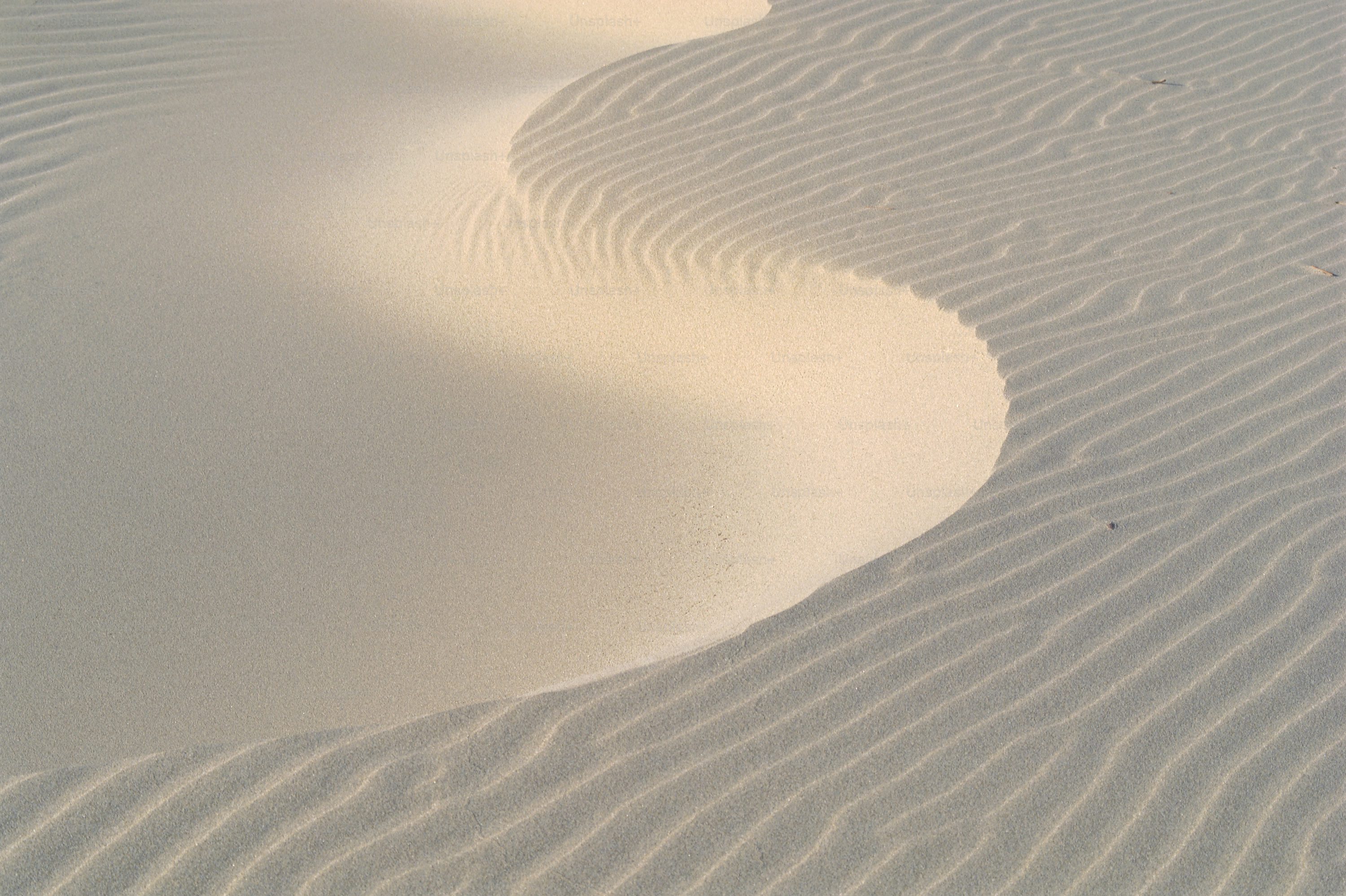 a person riding a snowboard on top of a sandy beach