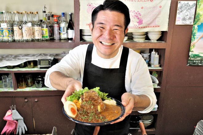 上野で店長を務める、沖縄出身のハンジロウ・しゅうごパークさん。「カリガリマキオカリー パーク店」は沖縄料理店を間借りしていて、ミニソーキや海ぶどうサラダがよくオーダーされるといいます＝筆者撮影