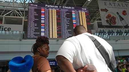 Passengers look at check-in times for flights during a nationwide strike of airports ground staff, and check-in services at Rome's Fiumicino Airport.