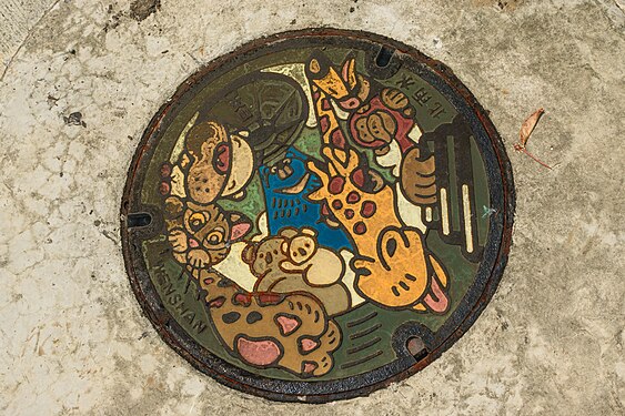 Painted rainwater manhole cover in Taipei city,Taiwan (2nd Style from Wenshan Dist. since 2021). Its depicted was included “A Formosan black bear lifts the manhole cover“ and Taipei Zoo’s representative animals
