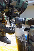 US Navy 090513-N-3289C-113 Explosive Ordnance Disposal Technician 1st Class Miller, assigned to the Explosive Ordnance Disposal Mobile Unit (EODMU) 8 Detachment Europe, Spain, applies plaster of Paris to an explosive device.jpg