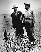 Robert Oppenheimer (left) and General Leslie Groves (right) at Ground Zero of the nuclear bomb test site.jpg