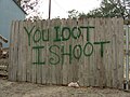 Message on fence: You Loot I Shoot