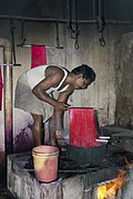 A man dyeing silk red in boiling water in Kumbakonam, Tamil Nadu.jpg