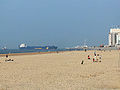 Beach with containership entering the harbour