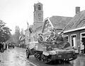 Royal Hamilton Light Infantry carriers move through the Dutch village of Krabbendijke on the Beveland Causeway, 27 October 1944.