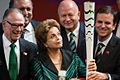 President Dilma Rousseff holding the Olympic torch, accompanied by the president of BOC Carlos Arthur Nuzman (left), and the Mayor of Rio de Janeiro, Eduardo Paes (right).
