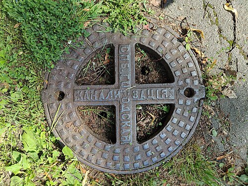 Old manhole cover in St. Petersburg with pre-revolutionary spelling