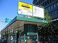 English: A sign marking a tram stop. Apparatus below tells minutes to tram arrivals Suomi: Ratikkapysäkin merkki, laite kertoo ratikan saapumisen